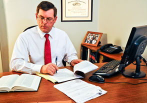 lawyer at his desk working on paperwork and working on his competer